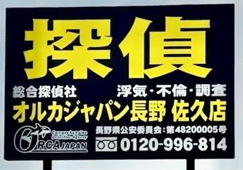 佐久市の道路沿いに立つ黒地に黄色の探偵看板